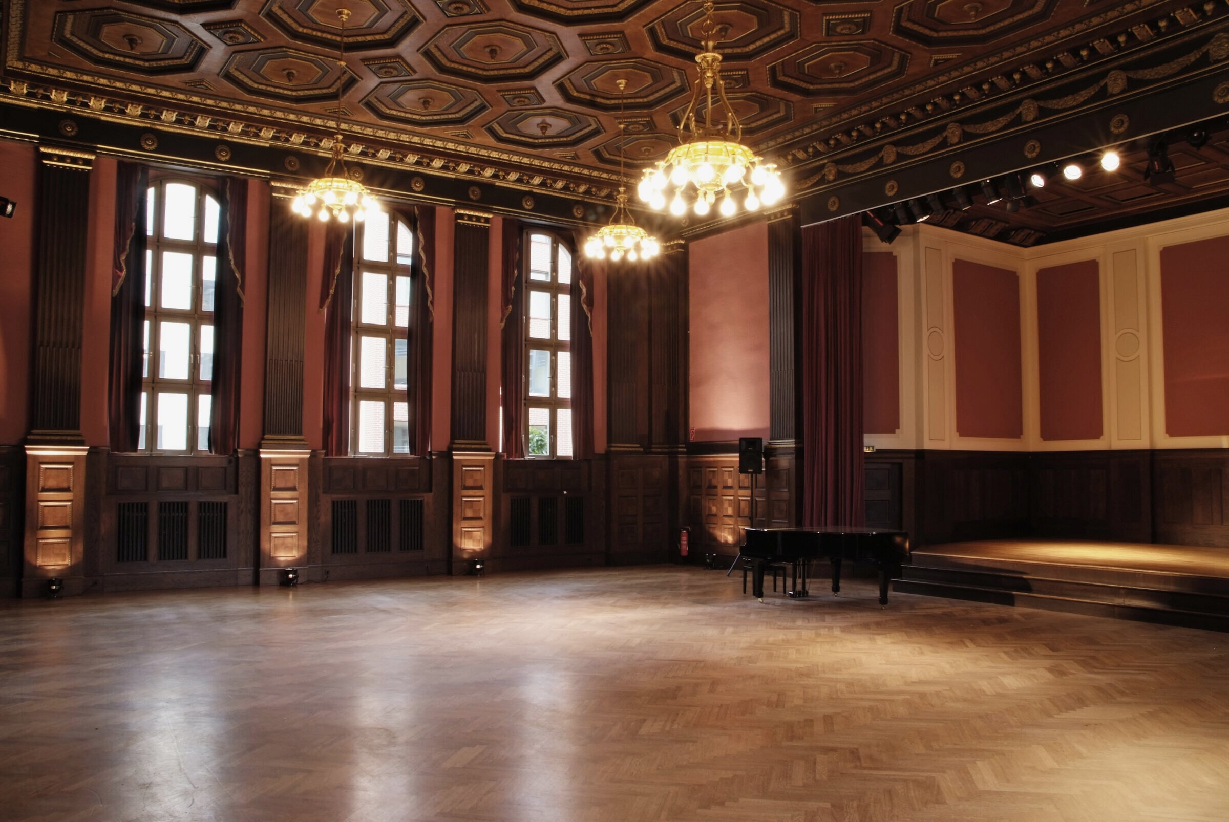 The empty Meistersaal at Hansa Studios: parquet floor, tall windows, chandelier, a grand piano at the far end.