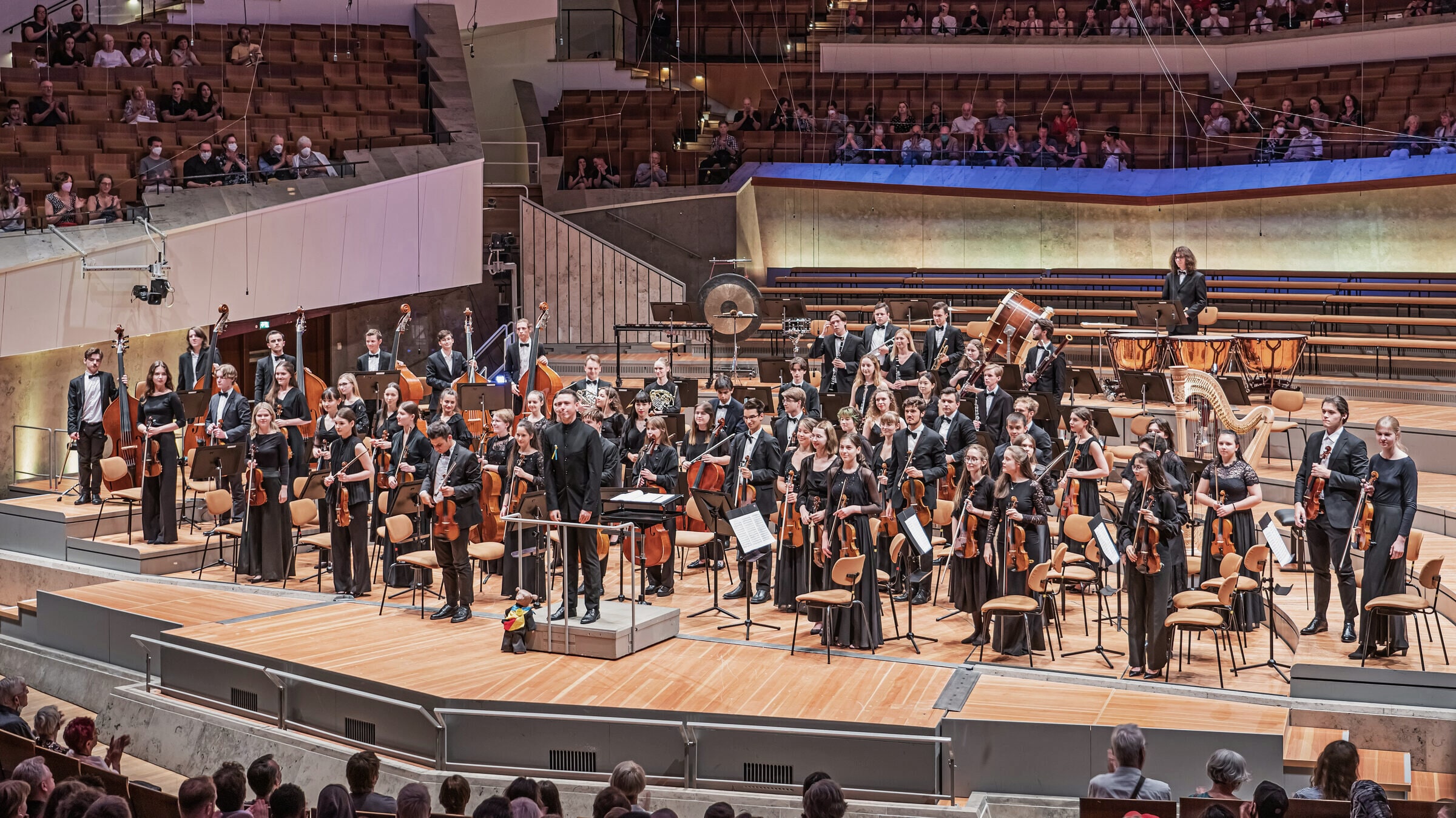 The main hall of the Berlin Philharmonie, orchestra on stage, terraced seating rising on every side.