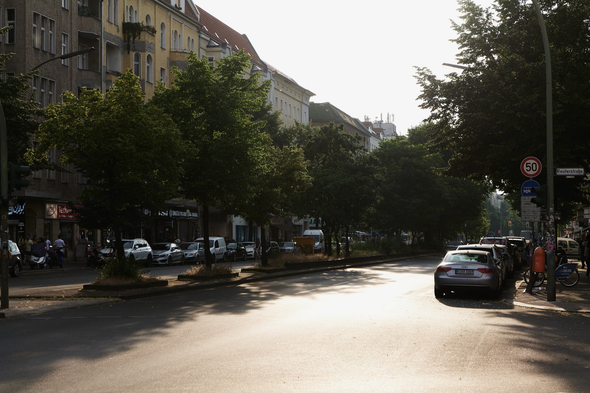 Sonnenallee in Neukölln, tree-lined, late afternoon light.