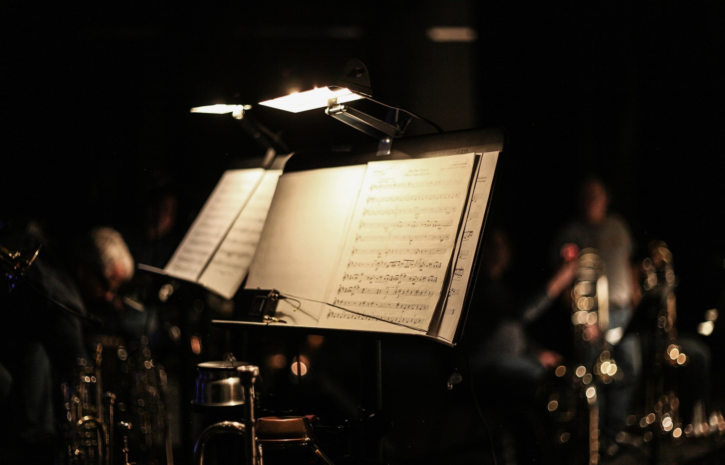 Empty music stands lit on a dark stage before rehearsal.