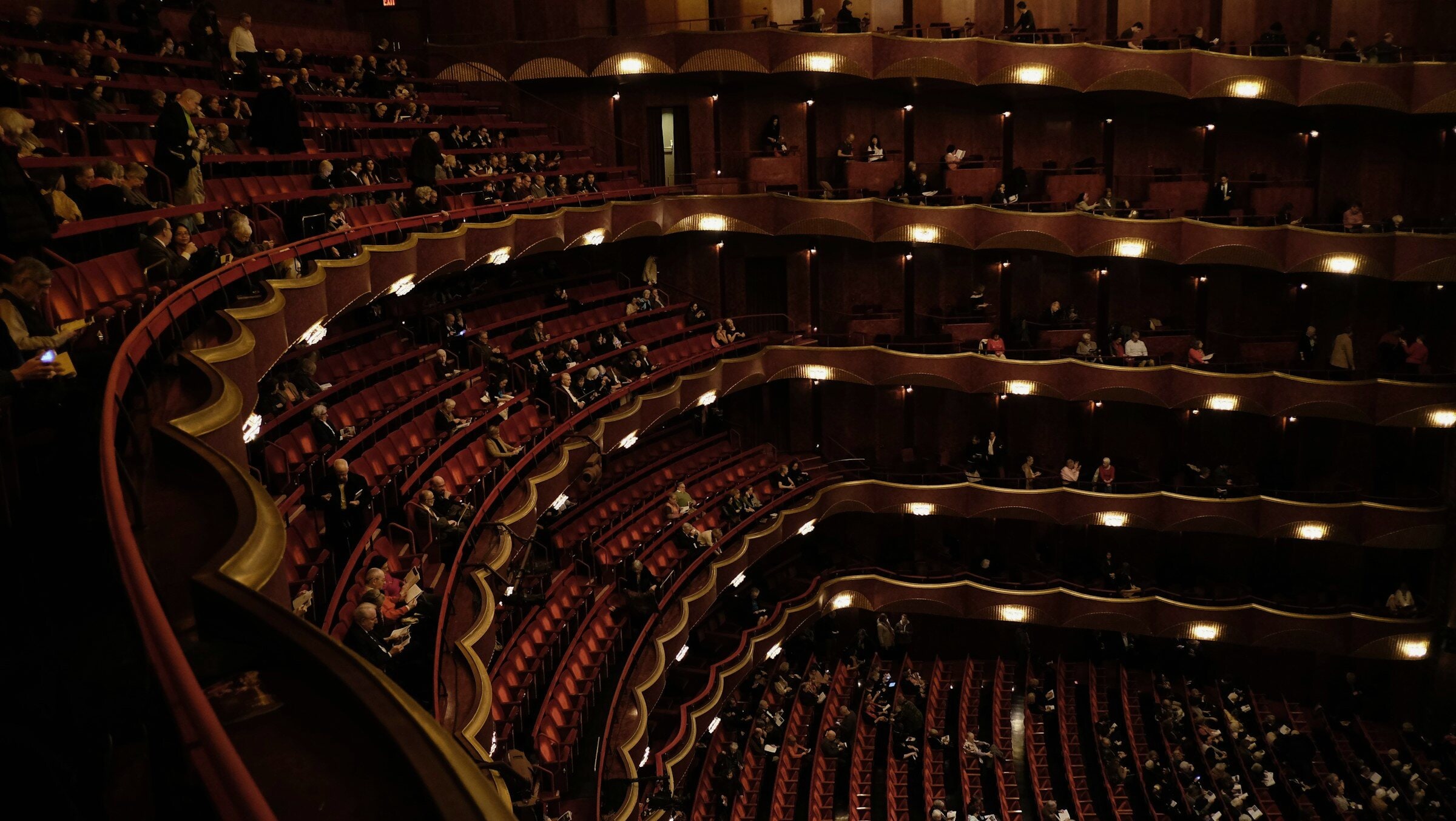 Red and gold tiers of an opera house, full.