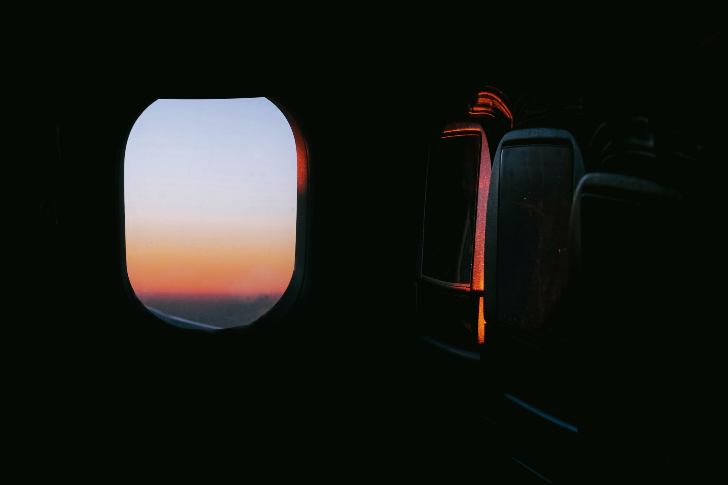 A dark cabin, one window glowing pink at dawn.